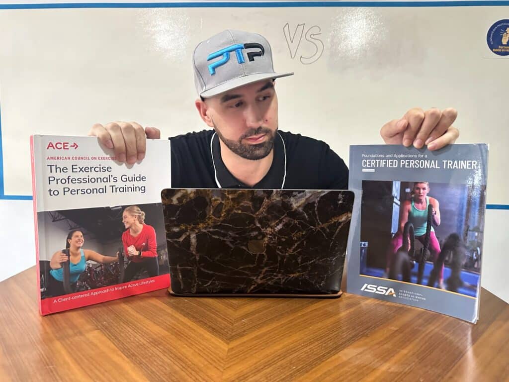 Tyler Read holds up ACE and ISSA textbooks on a table - ISSA vs ACE