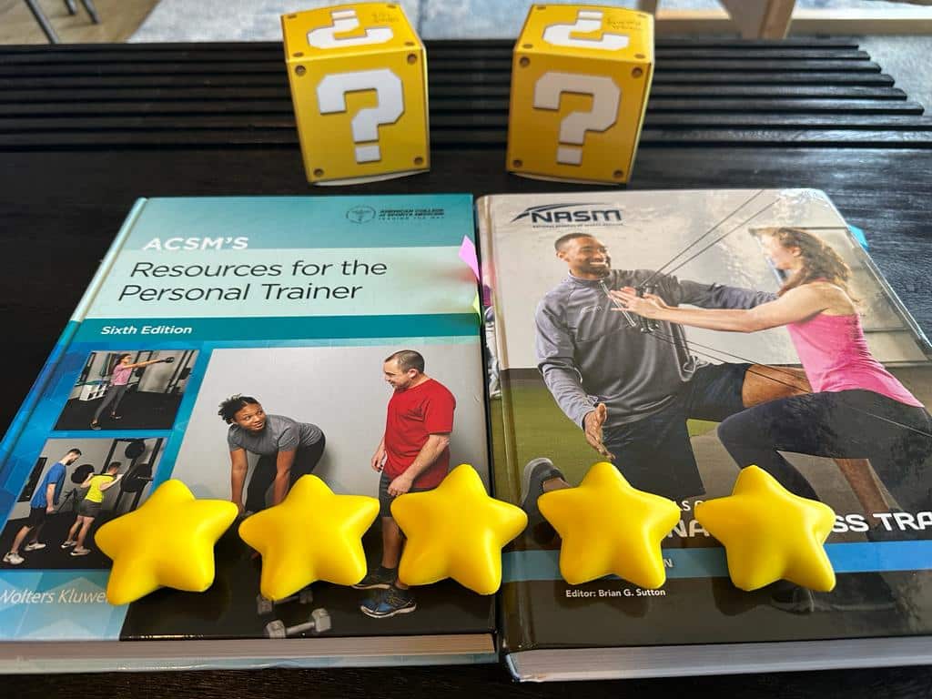 ACSM and NASM overall rating - ACSM and NASM textbooks on table with gold stars and question mark boxes