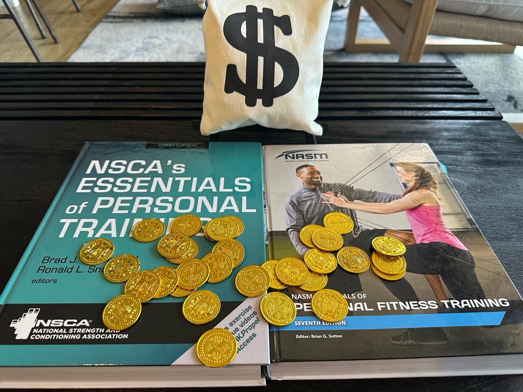 NSCA vs NASM - textbooks on table with gold coins and money bag on it