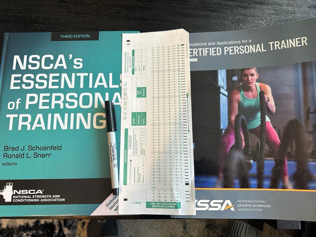 NSCA and ISSA exams compared - textbooks with scantron sheet in between them