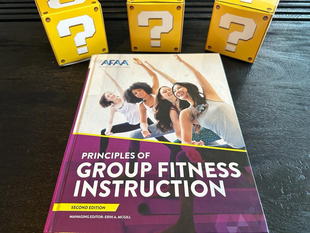 best training certifications - afaa group fitness textbook on table with yellow question mark boxes