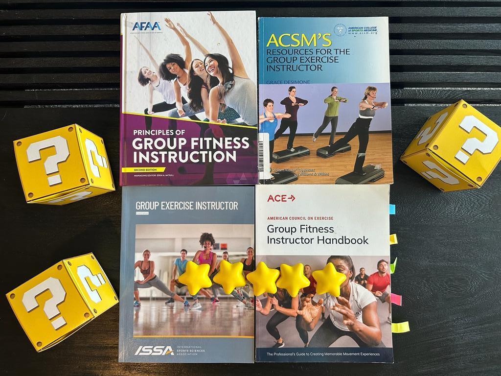 best group fitness certifications - GFI textbooks on table with yellow question mark boxes - which is the best gfi