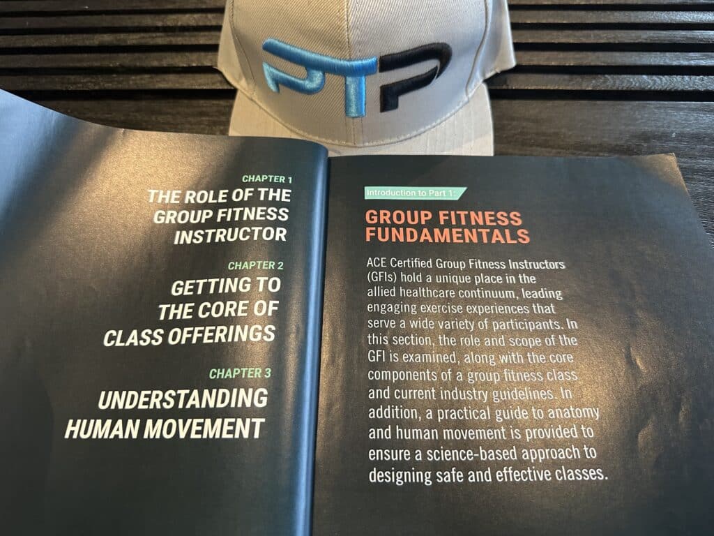 ace group fitness instructor - ace textbook open to table of contents next to ptpioneer hat - course layout 