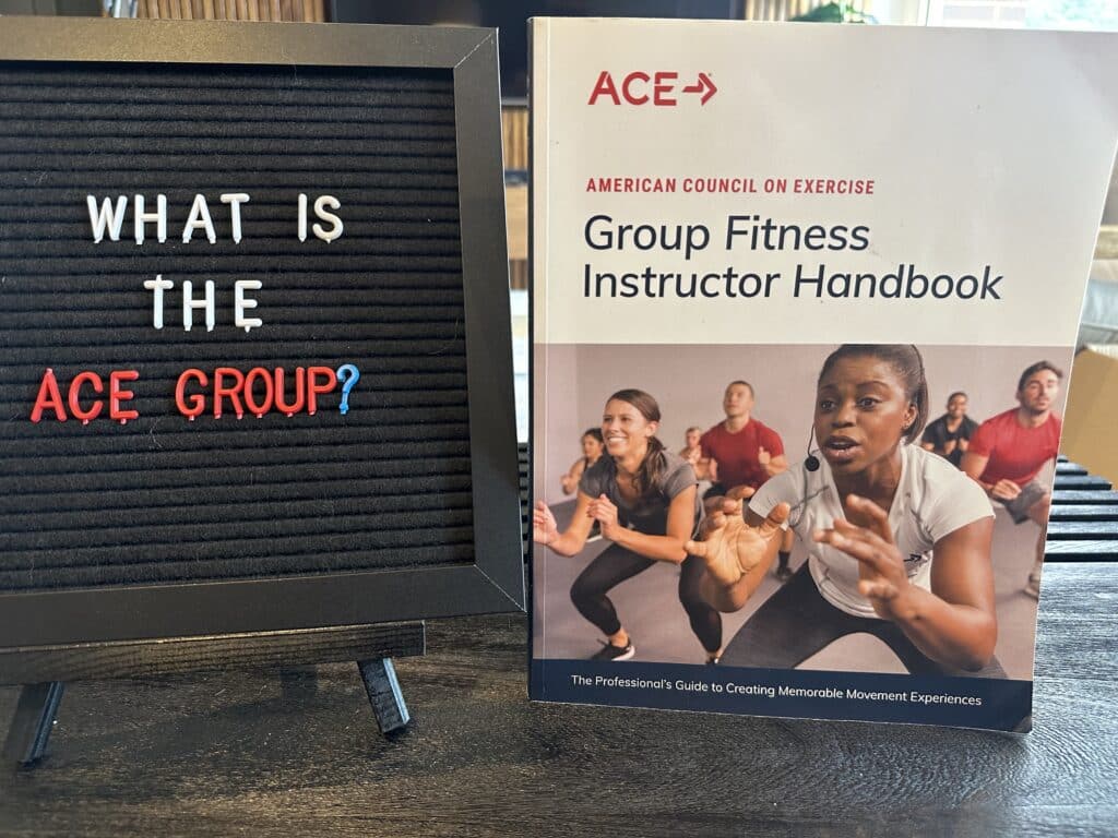 ACE group exercise instructor review - black board with what is the ace group on it next to the ace group instructor textbook