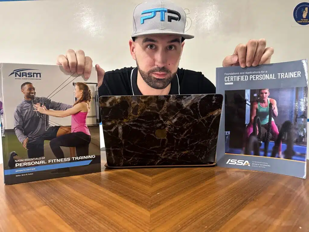 Comparing NASM and ISSA: Which Certification is Right for You? 32 ISSA vs NASM - Tyler read holds up NASM and ISSA textbooks on top of table - which is best?