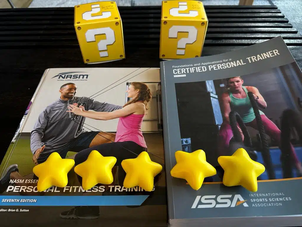 Comparing NASM and ISSA: Which Certification is Right for You? 62 NASM vs ISSA - textbooks for NASM and ISSA on table with stars and yellow question mark boxes - overall rating