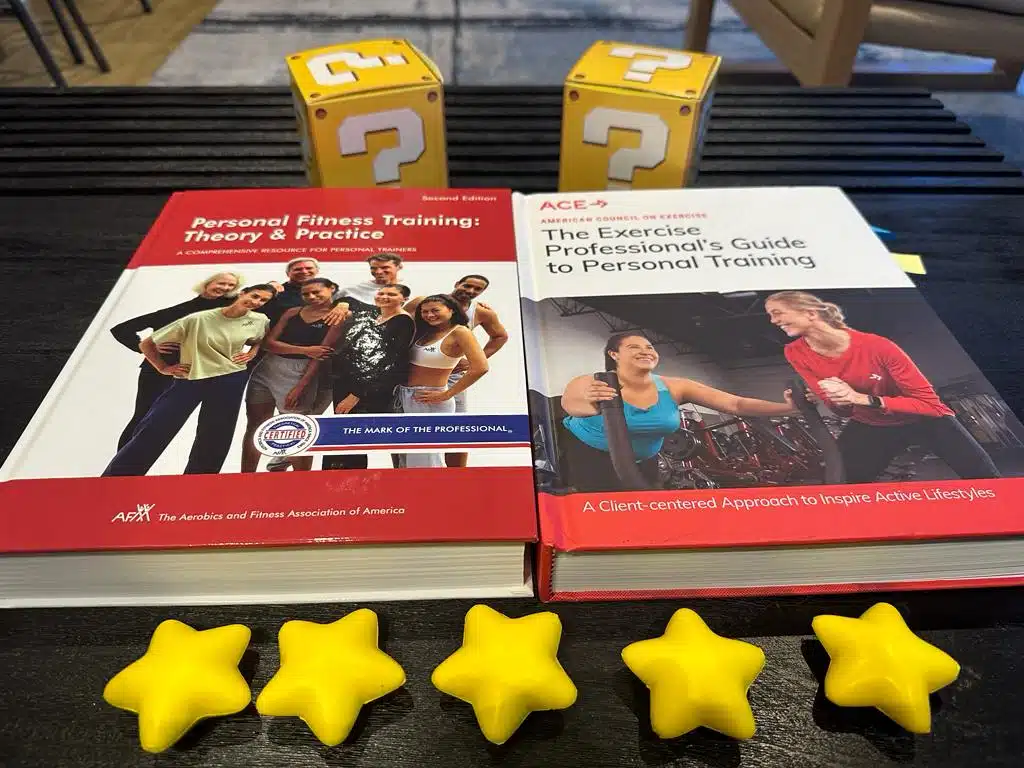ACE vs AFAA - textbooks for ACE and AFAA on table with gold stars and yellow question mark boxes - overall review of these cpts