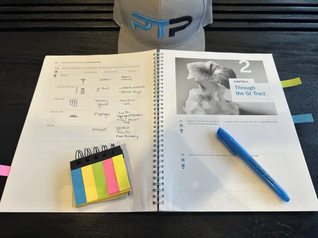 precision nutrition exam and study materials - precision nutrition certification textbook with notes laid out on table for studying