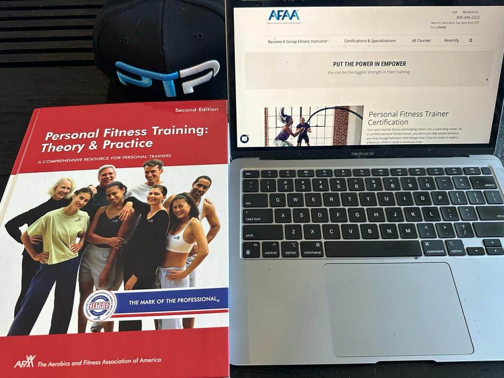 best online personal training certifications - afaa textbook next to laptop showing afaa website near ptp hat