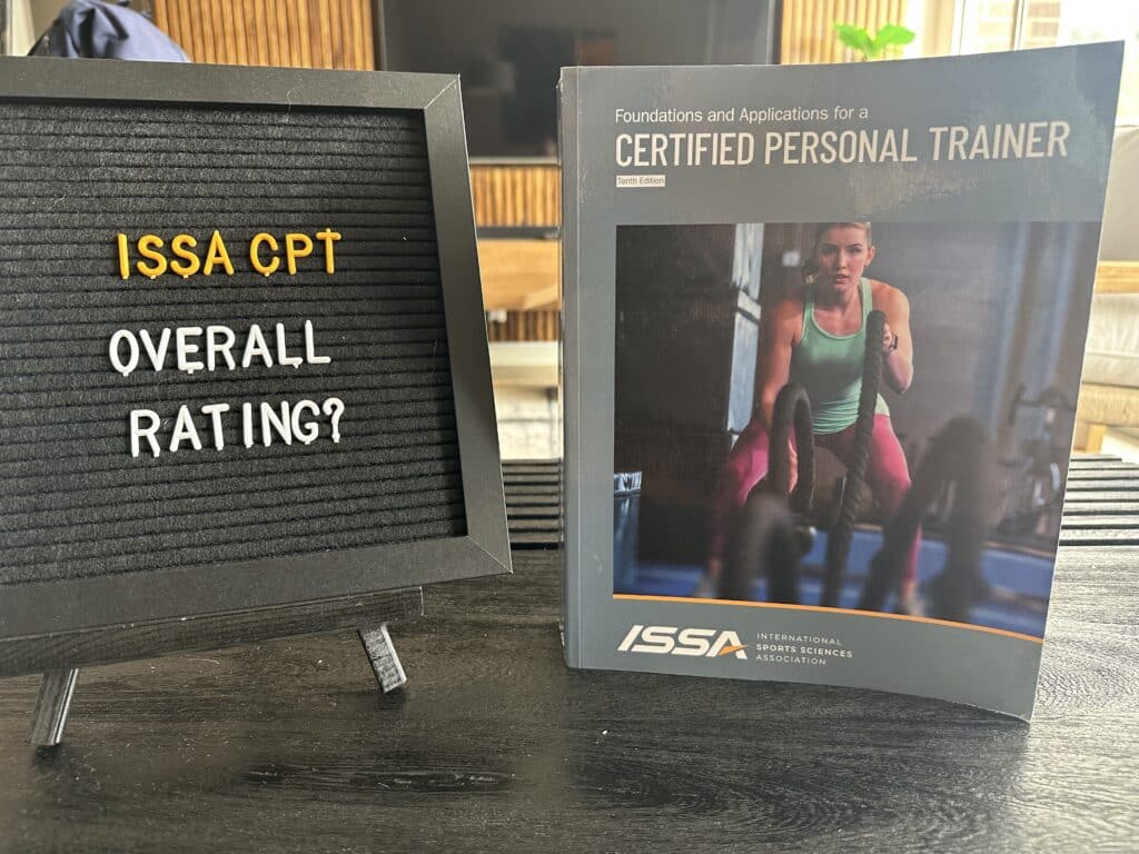 ISSA CPT program overall rating - ISSA trainer textbook on table with ISSA overall rating displayed