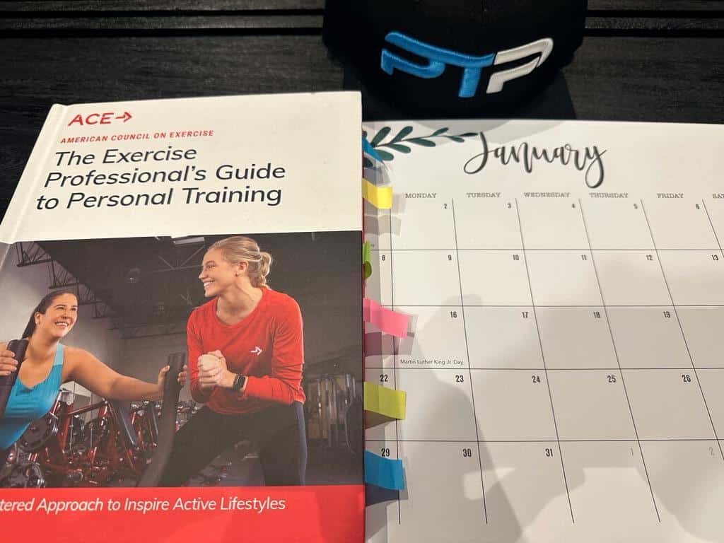 ACE CPT Study Plan - ACE personal trainer textbook, calendar laid out on table with dates for planning an ACE study session.