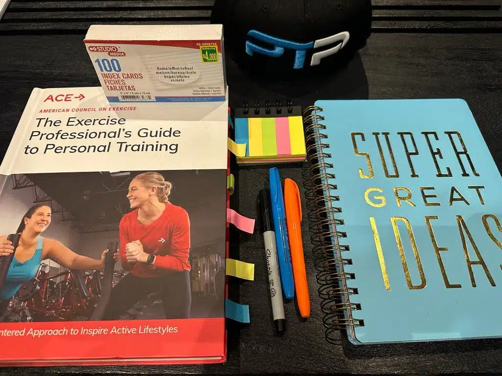 ACE CPT exam prep - ACE textbook laid on table with journal for taking notes in preparation for ACE exam prep.