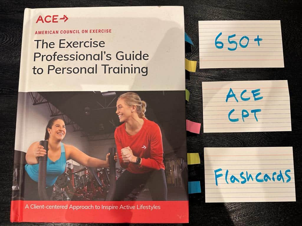 ACE personal trainer certification flashcards. ACE CPT textbook on table with study flashcards.