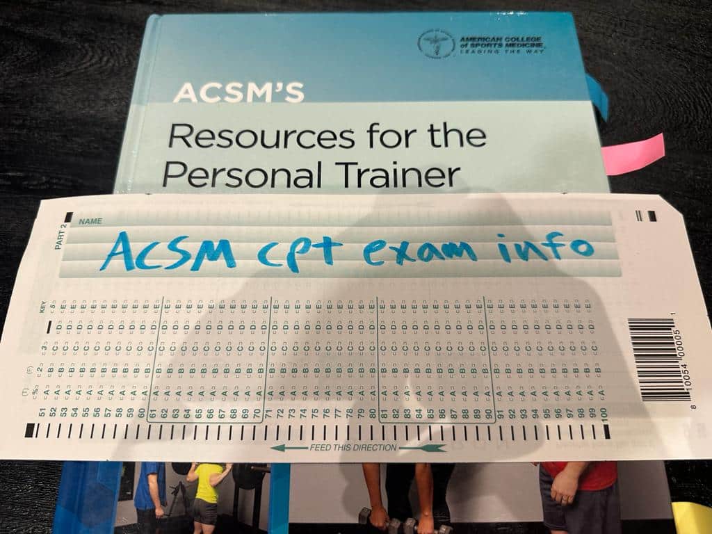 ACSM CPT Exam Info - ACSM textbook placed on table with scantron sheet.