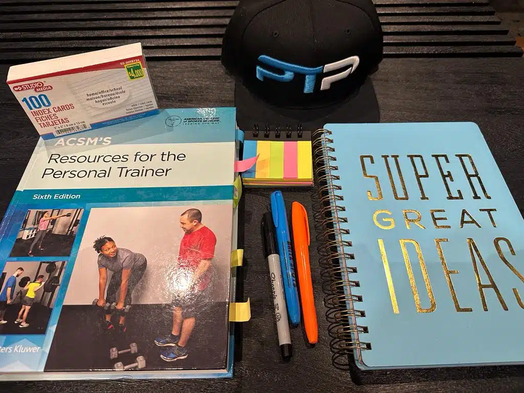 ACSM Exam Prep - ACSM textbook on table with journal for prepping for the final ACSM test.