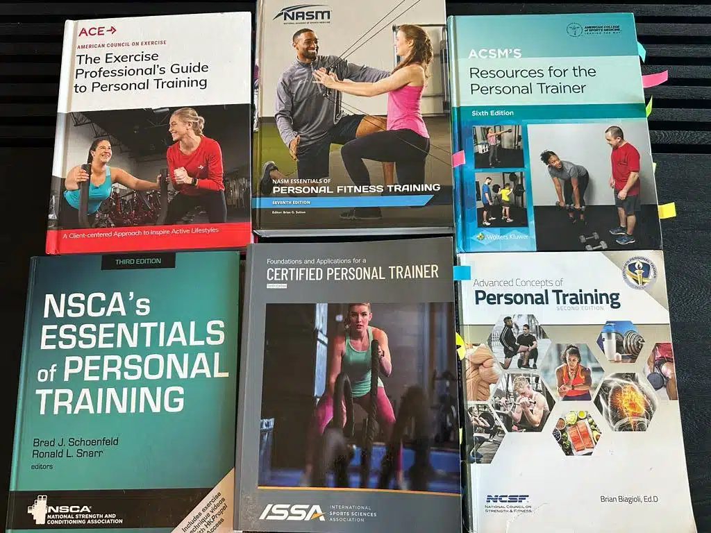 Best personal trainer certifications - textbooks lined up on table