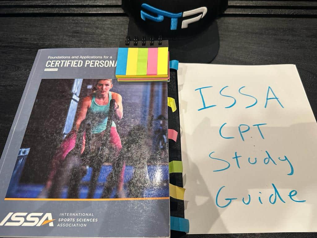 Free ISSA Study Guide - ISSA personal trainer textbook displayed on table for ISSA studying