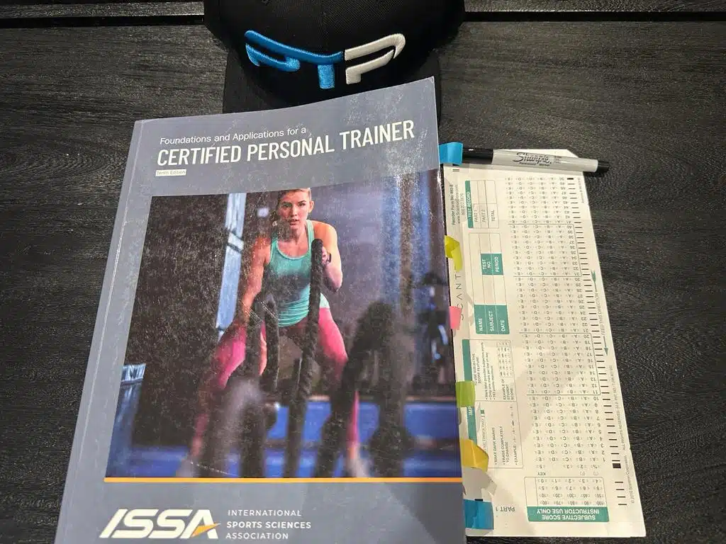 ISSA practice tests - ISSA personal trainer textbook laid out with ISSA exam scantron sheet to take the ISSA practice exams.