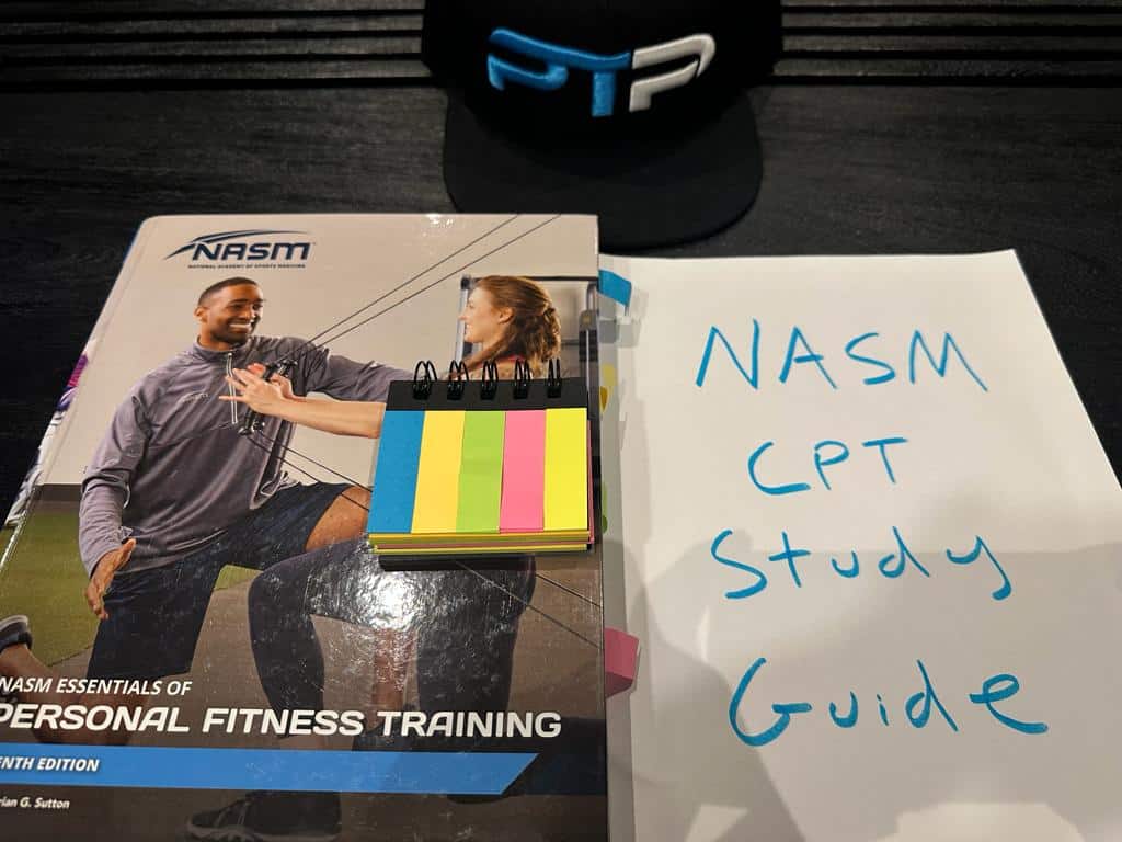 NASM CPT Study Guide - NASM Textbook on table with notes for studying the NASM personal trainer curriculum