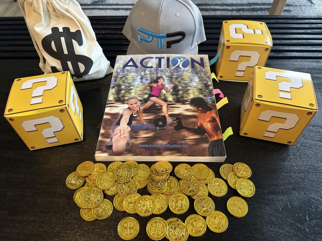 Action personal training certification cost - ACTION training textbook placed on table with gold coins