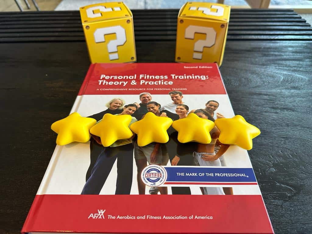 afaa personal trainer certification overall rating - afaa textbook on table with question mark boxes and stars