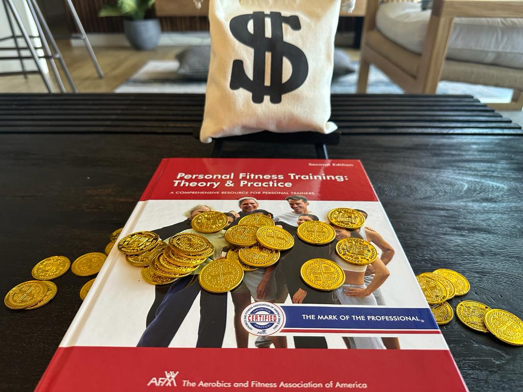 afaa personal training certification cost and study materials - AFAA textbook laid on table with gold coins and money bag