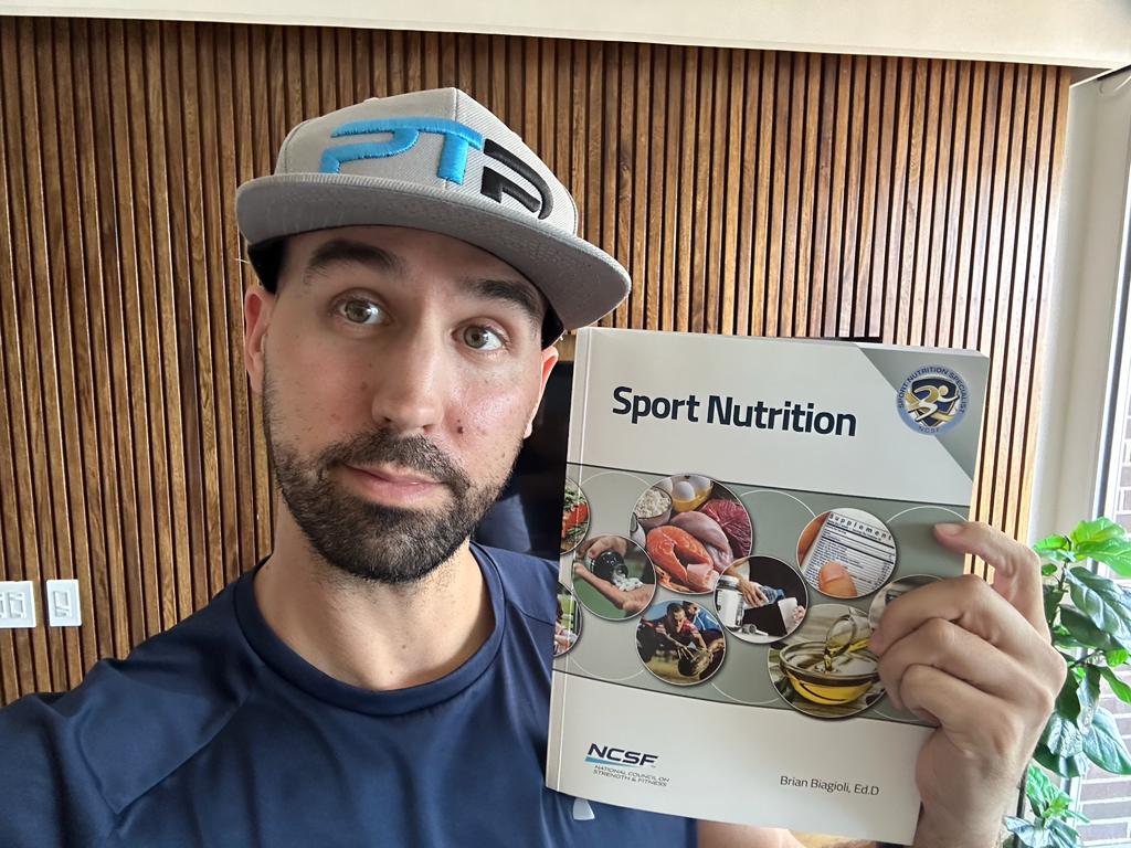 NCSF sports nutrition specialist review - Tyler Read holds the NCSF sport nutrition textbook.