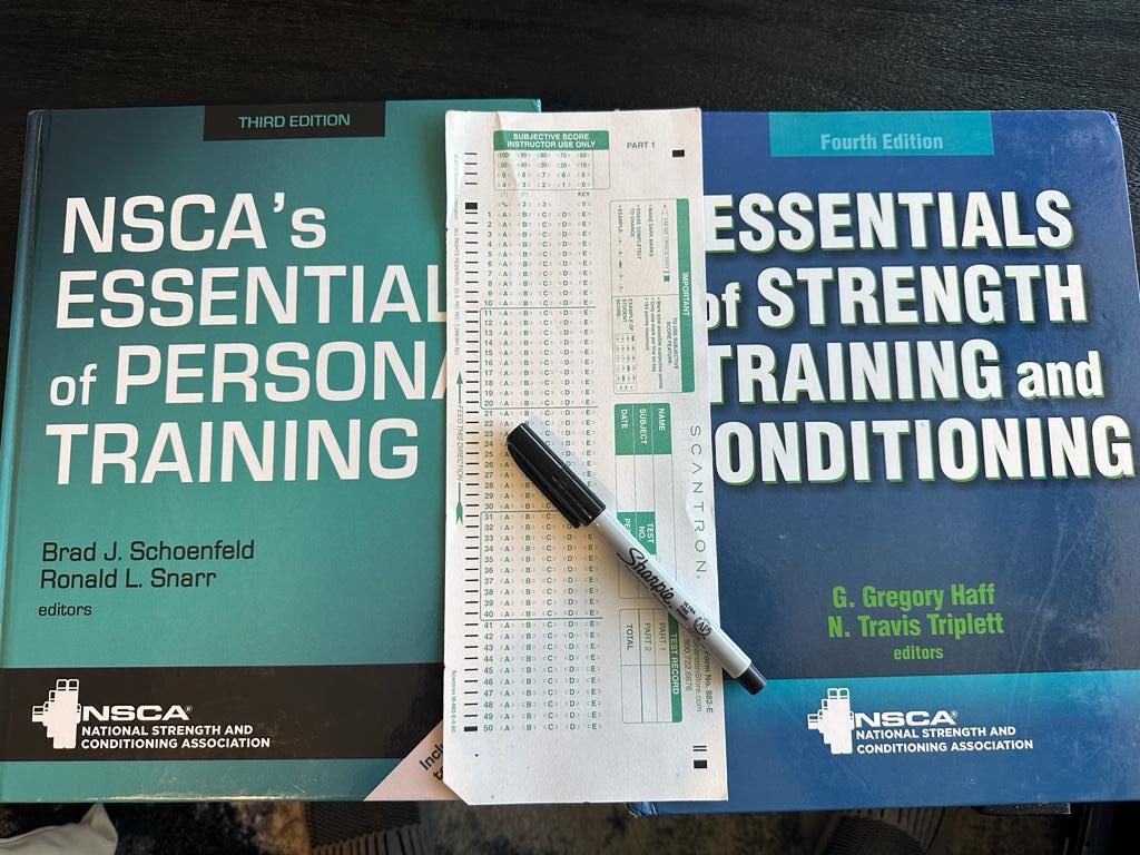 CPT vs CSCS - NSCA textbooks on table with scantron exam sheet and sharpie- which exam is harder?