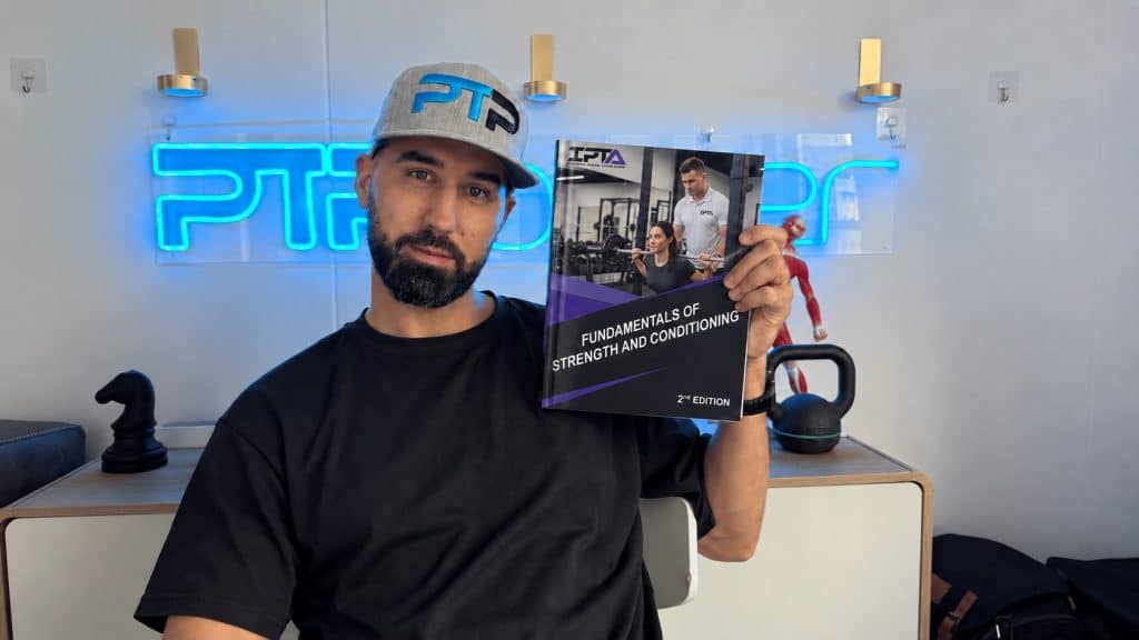 Tyler holds the strength and conditioning textbook for IPTA.