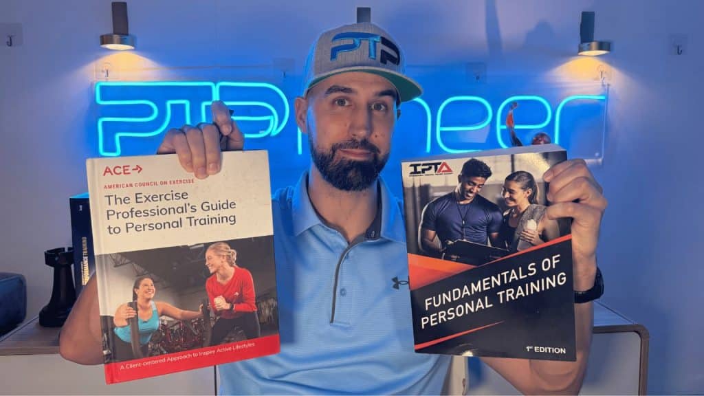 Tyler Read holds up ACE and IPTA textbooks, which is better